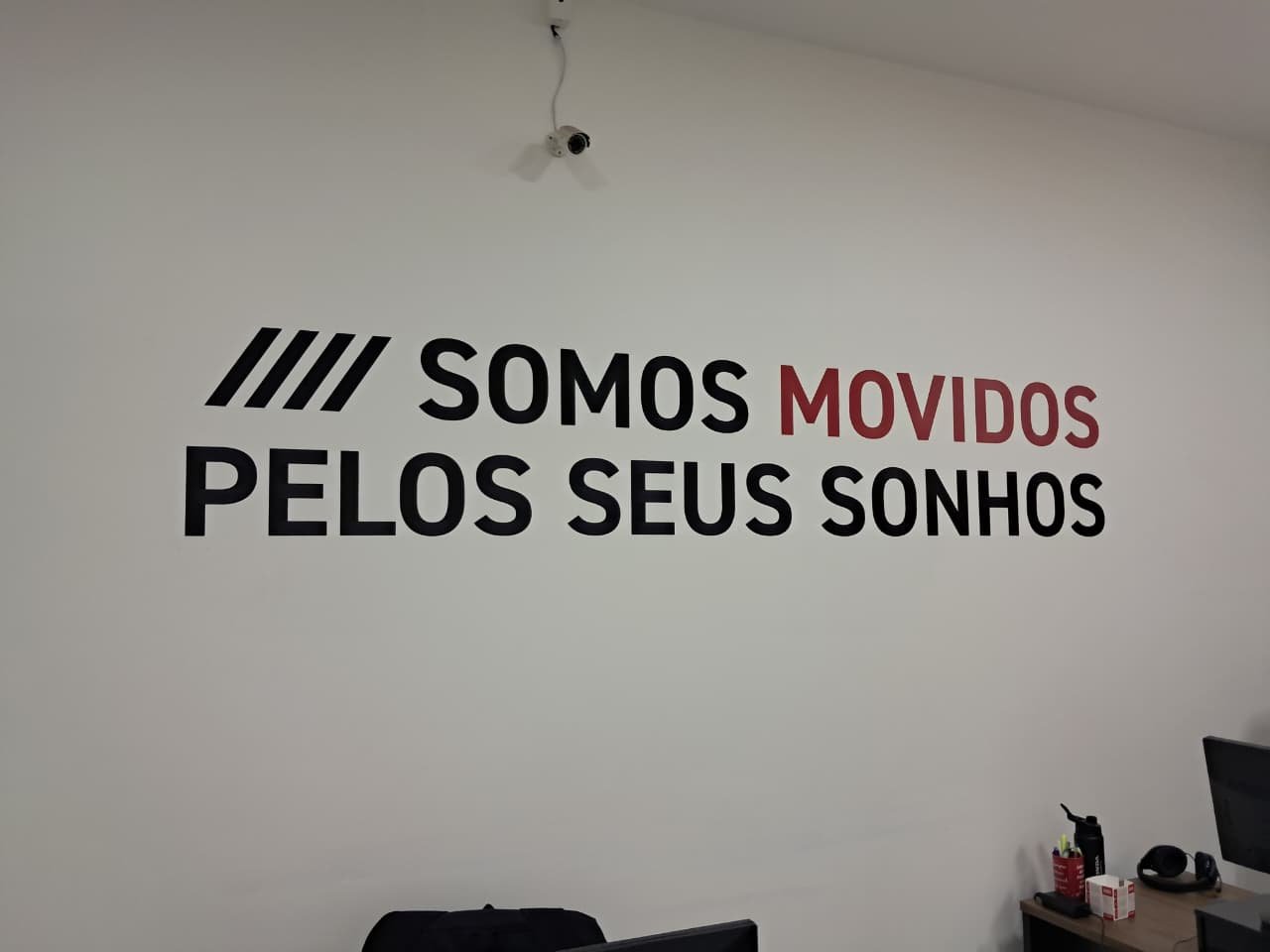 Frase adesivada em parede de escritório